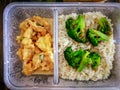 Different types of takeaway food in microwavable containers on a wooden background. Royalty Free Stock Photo