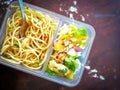 Different types of takeaway food in microwavable containers on a wooden background. Royalty Free Stock Photo