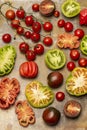 Different types of tomato, tomato halves and a sprig of cherry tomatoes