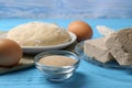 Different types of yeast, eggs, dough and flour in spoon on light blue wooden table