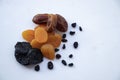 Different useful dried fruits on a white background. Prunes, dried apricots, dates and raisins. Appetizing picture for fruit Royalty Free Stock Photo