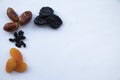 Different useful dried fruits on a white background. Prunes, dried apricots, dates and raisins. Appetizing picture for fruit Royalty Free Stock Photo