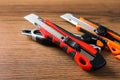 Different utility knives on wooden table, closeup. Construction tool Royalty Free Stock Photo