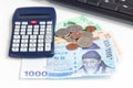 Different value South korean currency bill and coins near calculator and keyboard, save money concept