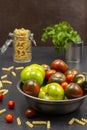 Different varieties of green and red tomatoes in a metal can. Pasta in a glass jar