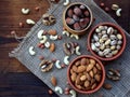 different varieties of nuts on a wooden background - almonds, cashews, walnuts, hazelnuts, pistachios