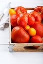 Different varieties of tomatoes on a wooden tray. Colorful red and yellow fresh ripe tomatoes Royalty Free Stock Photo