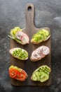 Vegan sandwiches with vegetables, radish, tomato on black. Appetizer for party Royalty Free Stock Photo