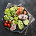 Different vegan sandwiches with vegetables, radish, tomato, rye bread on black. Appetizer for party Royalty Free Stock Photo