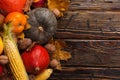 Different vegetables, pumpkins, apples, pears, nuts, tomatoes, corn, dry yellow leaves on wooden background. Autumn mood, copy Royalty Free Stock Photo