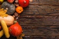 Different vegetables, pumpkins, apples, pears, nuts, tomatoes, corn, dry yellow leaves on wooden background. Autumn mood, copy Royalty Free Stock Photo