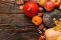 Different vegetables, pumpkins, apples, pears, nuts, tomatoes, corn, dry yellow leaves on wooden background. Autumn mood, copy Royalty Free Stock Photo