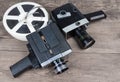 Different vintage amateur movie cameras and films on wooden surface