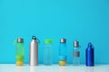 Different water bottles for sports on color background