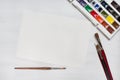 Different watercolor paintbrushes with colors and paper