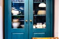 Different white dishes in cupboard in the kitchen vintage design with blue colors Royalty Free Stock Photo