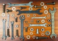 Different wrenches, bolts, nuts and washers on a brown wood texture background Royalty Free Stock Photo