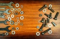 Different wrenches, bolts, nuts and washers on a brown wood texture background Royalty Free Stock Photo