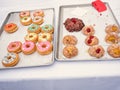 Differently decorated donuts on a baking tray