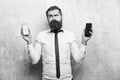 Difficult choice. hipster or bearded man compare mobile phone and smartphone Royalty Free Stock Photo