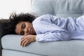 Exhausted millennial african american woman fall asleep on couch Royalty Free Stock Photo
