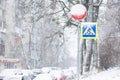 difficult road conditions - road in the winter snowfall with pedestrian crossing sign Royalty Free Stock Photo