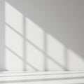 Diffuse sunlight casts geometric shadows of window panes on a smooth white wall Royalty Free Stock Photo