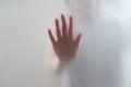 Diffused silhouette of female hands through plastic