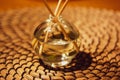 Diffusoria on rattan table. Glass bottle with aroma sticks. Fragrance home decor