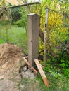 Dig a deep hole in the soil to pour mortar on the fence posts to strengthen the foundation