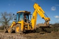 Digger in countryside clearing ditch