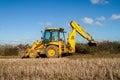 Digger in countryside clearing ditch