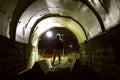 Digger with the lantern in the dark tunnel turned on - Diggery in an abandoned industrial room Royalty Free Stock Photo