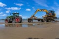 Digger on trailer behind tractor on beach Royalty Free Stock Photo