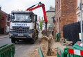 Palfinger Epsilon M125 Grab crane on a tipper truck working on utility repairs under the pavement.