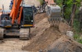 Digger working by digging soil at construction site. Bucket teeth of backhoe digging sand. Crawler excavator digging on soil.