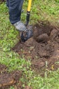 Digging the earth with a spade at countryside. Male foot wearing a rubber boot digging the earth with a spade. iron