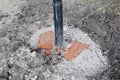 Digging holes and installing fence metal pillars with concrete foundation