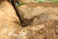 Digging a trench. Earthworks, digging trench. Long earthen trench dug to lay pipe or optical fiber Royalty Free Stock Photo