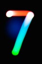 Digit 7. Seven. Glowing numbers on dark background. Abstract light painting at night. Creative artistic colorful bokeh. New Year. Royalty Free Stock Photo