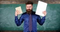 Digital against paper. Teacher bearded hipster holds book and laptop. What would you prefer. Teacher choosing modern