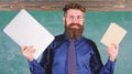 Digital against paper. Teacher bearded hipster holds book and laptop. What would you prefer. Teacher choosing modern