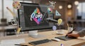 Digital artist creating vibrant graphic design on a modern computer setup with creative tools floating Royalty Free Stock Photo