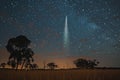 Digital artwork of  bright comet in the night sky over an open field with trees Royalty Free Stock Photo