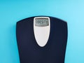 Digital bathroom scale with the word obesity on blue background