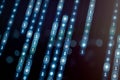 Digital binary code flowing vertically with glowing blue effect, representing cybersecurity, artificial intelligence, blockchain, Royalty Free Stock Photo