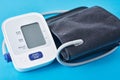 Digital blood pressure monitor on a blue background, closeup. Helathcare and medical concept