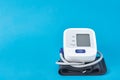 Digital blood pressure monitor on a blue background, closeup. Helathcare and medicine concept