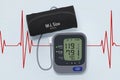 Digital Blood Pressure Monitor with Cuff on Cardiogram Backgrou