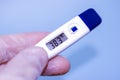 Digital body thermometer in human hands display high temperature